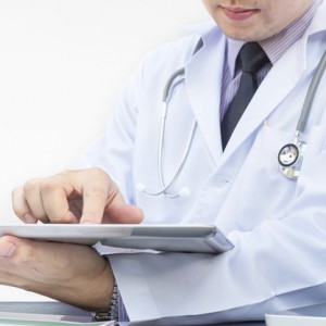 Doctor is working with tablet over white background