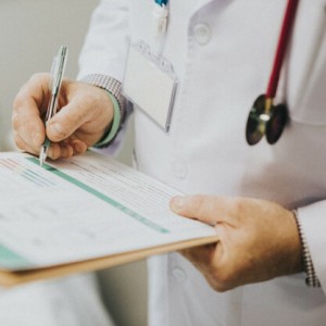 Physician noting down symptoms of a patient