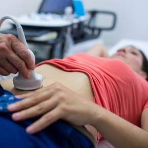 Woman getting ultrasound of a abdomen from doctor in hospital